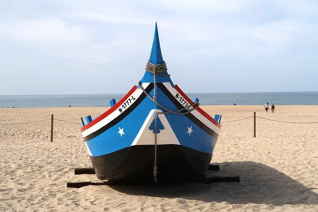 Bateaux de pêche colorés sur la plage de Nazaré au Portugal avec la culture maritime traditionnelle