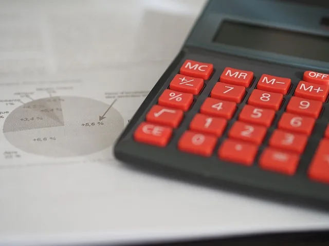 Red calculator with financial pie chart used for comparing car insurance prices in Portugal