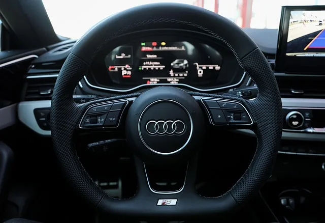 Volant et tableau de bord numérique d'une Audi moderne représentant les options d'assurance auto au Portugal